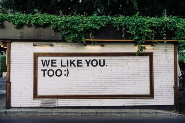 Store sign/side of building that says "We Like You Too"